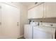 Functional laundry room with washer, dryer, overhead cabinets and exterior access door at 1871 Leisure World --, Mesa, AZ 85206