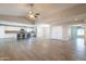 Open-concept living area featuring wood-look flooring, vaulted ceilings, and a modern kitchen with bar seating at 1871 Leisure World --, Mesa, AZ 85206