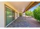 Extended covered patio features brick pavers and views of mature trees in gravel yard at 1871 Leisure World --, Mesa, AZ 85206