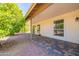 Covered patio and landscaped backyard featuring brick pavers and fruit bearing trees at 1871 Leisure World --, Mesa, AZ 85206