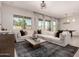 Stylish living room featuring a large sectional sofa, modern decor, and ample natural light at 19038 N Arbor Dr, Maricopa, AZ 85138