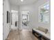 Bright hallway with hardwood floors, a bench, and a view into the adjacent living room. Lots of light from the windows at 2153 E Cherrywood Pl, Chandler, AZ 85249