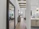 Hallway with hardwood floors, exposed beams, large mirror, and view to living area at 2153 E Cherrywood Pl, Chandler, AZ 85249