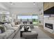 Open living room with a large sectional sofa, modern fireplace, and seamless indoor-outdoor living at 2153 E Cherrywood Pl, Chandler, AZ 85249