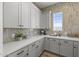 Butler's pantry features bright white cabinets, tiled backsplash, and quartz countertops at 2153 E Cherrywood Pl, Chandler, AZ 85249