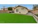 Backyard featuring artificial turf, patio furniture, and a paved walkway with lush greenery at 21940 N 69Th Dr, Glendale, AZ 85310