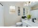 Well-lit bathroom with a white vanity, dark fixtures, and a large mirror enhancing the space at 21940 N 69Th Dr, Glendale, AZ 85310