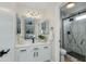 Stylish bathroom with a modern vanity, decorative mirror, sleek lighting, and glass-enclosed shower at 21940 N 69Th Dr, Glendale, AZ 85310