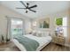 Bright bedroom featuring a large bed, modern decor, and sunlit windows with a view of the landscaped yard at 21940 N 69Th Dr, Glendale, AZ 85310
