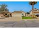 Charming single-story home featuring a tiled roof, attached garage, manicured lawn, and mature trees at 21940 N 69Th Dr, Glendale, AZ 85310