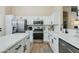 Modern kitchen featuring white cabinetry, stainless steel appliances, and a center island with quartz countertops at 21940 N 69Th Dr, Glendale, AZ 85310