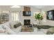 Bright living room with a fireplace, large sectional sofa, modern decor, and ample natural light at 21940 N 69Th Dr, Glendale, AZ 85310