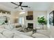 Stylish living area with a fireplace, ceiling fan, and a large sectional sofa for comfortable gatherings at 21940 N 69Th Dr, Glendale, AZ 85310