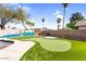 Lush backyard featuring a putting green, a pool, and a colorful mural, creating a fun and relaxing atmosphere at 2232 E Karen Dr, Phoenix, AZ 85022
