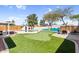 Spacious backyard with a pool, putting green, lounge area, and colorful mural, perfect for outdoor enjoyment at 2232 E Karen Dr, Phoenix, AZ 85022