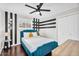 Stylish bedroom with bold striped accent wall, sleek furniture, and a ceiling fan, creating a chic space at 2232 E Karen Dr, Phoenix, AZ 85022