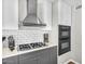 Updated kitchen features stainless steel gas range, subway tile backsplash, and modern gray cabinets at 2232 E Karen Dr, Phoenix, AZ 85022