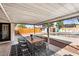 Outdoor patio boasting a dining table and chairs, with a sparkling pool and lounge chairs in the background at 2232 E Karen Dr, Phoenix, AZ 85022