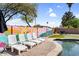 Inviting pool area with lounge chairs, a colorful mural, and lush greenery, perfect for relaxation at 2232 E Karen Dr, Phoenix, AZ 85022