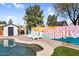 Backyard pool area with lounge chairs and a vibrant Phoenix mural, creating a fun and inviting outdoor space at 2232 E Karen Dr, Phoenix, AZ 85022
