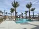 Resort-style community pool surrounded by palm trees, lounge chairs, and shade structures at 22812 E Lords Way, Queen Creek, AZ 85142