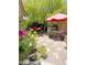 Inviting backyard area with patio furniture, a vibrant umbrella, and lush landscaping at 2394 E Santiago Trl, Casa Grande, AZ 85194