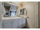 Bright bathroom featuring white cabinetry, a large mirror and a double sink at 2394 E Santiago Trl, Casa Grande, AZ 85194