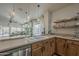 Bright kitchen features stainless steel dishwasher, wooden cabinets, and view into the living area at 2394 E Santiago Trl, Casa Grande, AZ 85194