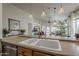 Kitchen with double sink, faucet, pendant lighting, and view of the living area at 2394 E Santiago Trl, Casa Grande, AZ 85194