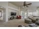 Spacious living room with a ceiling fan, large TV, backyard access, and comfortable seating at 2394 E Santiago Trl, Casa Grande, AZ 85194