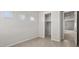 Bedroom with neutral tile flooring, three windows, closet, and door leading to the hall at 2530 N Pony Ln, Casa Grande, AZ 85122