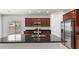 Kitchen island featuring a sink and a sleek black countertop surrounded by dark wood cabinetry at 2530 N Pony Ln, Casa Grande, AZ 85122