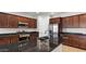 Kitchen with a dark island countertop, stainless steel appliances, and dark wood cabinets at 2530 N Pony Ln, Casa Grande, AZ 85122