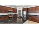 Kitchen with a dark island countertop, stainless steel appliances, and dark wood cabinets, and a pantry at 2530 N Pony Ln, Casa Grande, AZ 85122