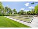 Well-maintained bocce ball courts with lush greenery and shaded seating, creating a serene recreational space at 26733 W Melinda Ln, Buckeye, AZ 85396