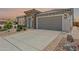 A charming home exterior featuring a stone facade, three-car garage, and beautifully paved driveway at 26733 W Melinda Ln, Buckeye, AZ 85396