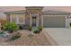 Charming stone home with a tiled roof, landscaped yard, and a gray garage door at 26733 W Melinda Ln, Buckeye, AZ 85396