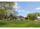Picturesque golf course featuring lush green grass, mature trees, and scenic mountain views on a sunny day at 26733 W Melinda Ln, Buckeye, AZ 85396