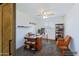 Well-lit home office with an industrial-style desk, shelving, and a comfortable chair at 26733 W Melinda Ln, Buckeye, AZ 85396