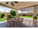 Cozy covered patio with outdoor seating and a view of the lush backyard and landscaping at 26733 W Melinda Ln, Buckeye, AZ 85396