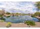 Scenic pond surrounded by landscaping, offering a tranquil view within a residential community at 26733 W Melinda Ln, Buckeye, AZ 85396