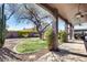 Inviting backyard with covered patio, lush lawn, desert landscaping, and mature trees offering shade at 29023 N 48Th Ct, Cave Creek, AZ 85331