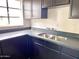 U-shaped kitchen features black cabinetry, gray countertops, and stainless steel sink at 2925 N 19Th Ave # 97, Phoenix, AZ 85015