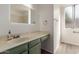 Bright bathroom featuring a single sink, wooden cabinets, and large window at 3030 W Christy Dr, Phoenix, AZ 85029