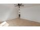 A spacious bedroom with a ceiling fan, tile flooring, and a view to the adjacent room at 3030 W Christy Dr, Phoenix, AZ 85029