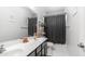 Bathroom featuring a double sink vanity, white countertops, and decorative mirror and a gray shower curtain at 31318 N 26Th Dr, Phoenix, AZ 85085