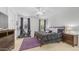 Primary bedroom with a ceiling fan, bed with black comforter, two windows, exercise bike and purple accents at 31318 N 26Th Dr, Phoenix, AZ 85085