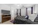 Primary bedroom with a ceiling fan, bed with black comforter, two windows, exercise bike and purple accents at 31318 N 26Th Dr, Phoenix, AZ 85085