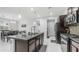 Bright kitchen with stainless steel appliances, an island, pendant lights, dark cabinetry and access to the dining area at 31318 N 26Th Dr, Phoenix, AZ 85085