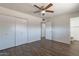 Bedroom featuring hardwood floors, a ceiling fan, spacious closets and an ensuite bathroom at 3441 W Sweetwater Ave, Phoenix, AZ 85029